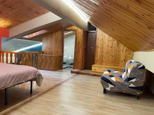 una camera da letto con un letto, una sedia e un bagno di Montaria Suite a Pescocostanzo