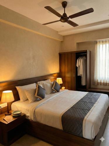 a bedroom with a large bed with a ceiling fan at Hanuman Heritage in Chikmagalūr