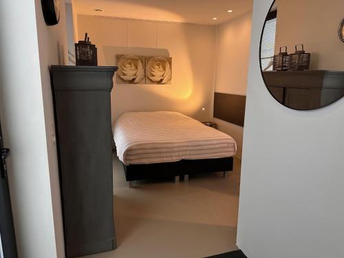 een kleine kamer met een klein bed en een spiegel bij Villa View in Alkmaar