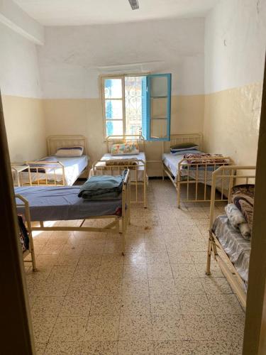 ein Zimmer mit vier Betten in einem Zimmer in der Unterkunft Hotel des Alliés in Tunis