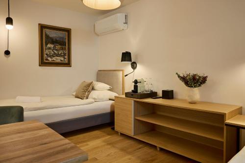 Habitación de hotel con cama y escritorio con flores en Villa Bayer, en Villány