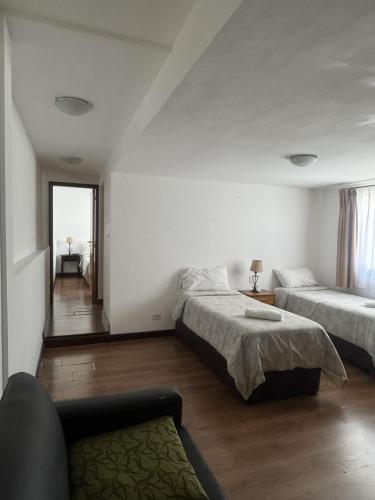 a bedroom with two beds and a couch in it at NBH Premier Hotel in San Carlos de Bariloche