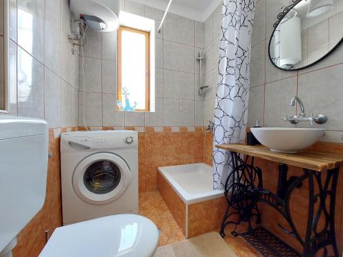 a bathroom with a washing machine and a sink at House House Jadranovo in Jadranovo
