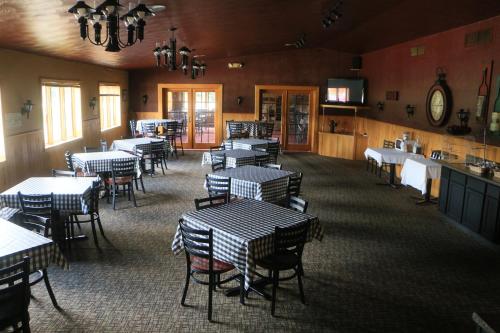 Wetmore的住宿－Econo Lodge Inn & Suites Munising Area，一间在房间内配有桌椅的餐厅