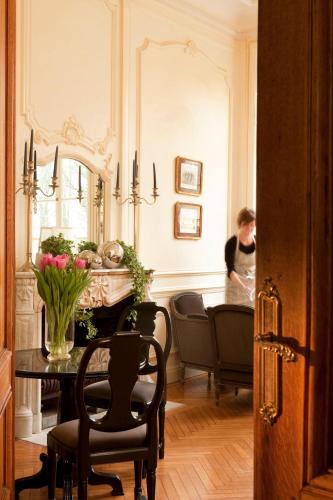 a woman standing in a room with a table and a mirror at Château de la Marine in Wimille