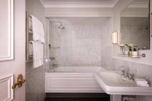a white bathroom with a tub and a sink at Rookery Hall Hotel & Spa in Nantwich