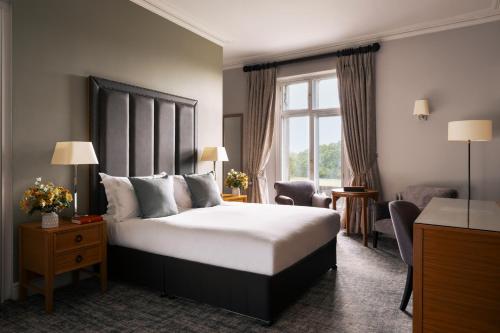 a hotel room with a large bed and a window at Rookery Hall Hotel & Spa in Nantwich
