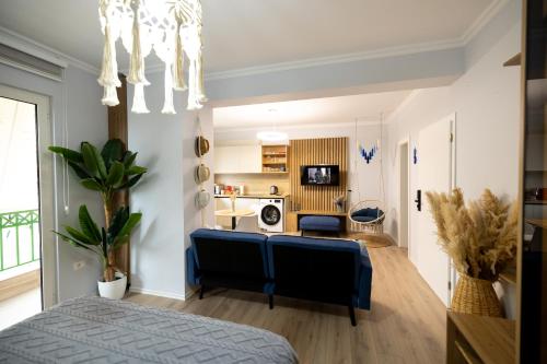 sypialnia z niebieską kanapą i salonem w obiekcie Boho Central Apartment w Tiranie