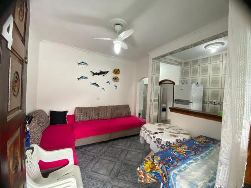 a living room with a red couch and a bed at Casa de Praia Bertioga-Costa do Sol Guaratuba in Bertioga