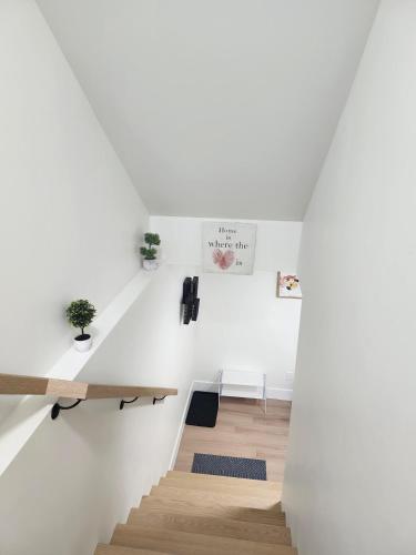 a staircase in a house with white walls and wooden floors at Oasis Haven in Moncton