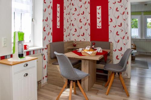 een keuken met een tafel en stoelen en rode muren bij Ferienwohnung-Margarete in Sankt Andreasberg