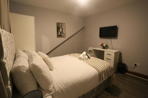 a bedroom with a bed with a teddy bear on it at Heathrow roomzzzz BnB in Hayes