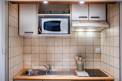 una cocina con fregadero y microondas en Hôtel des Touristes, en Pierrefitte-Nestalas