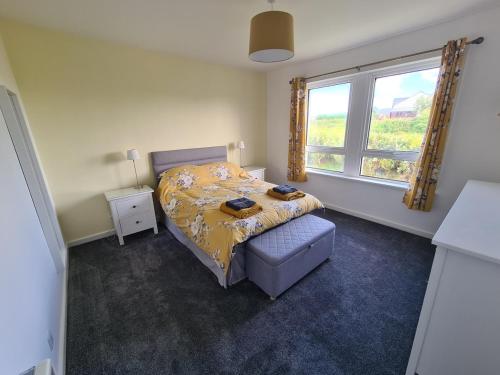 een slaapkamer met een bed en een raam bij Beachcroft Cottage in Aird Tong