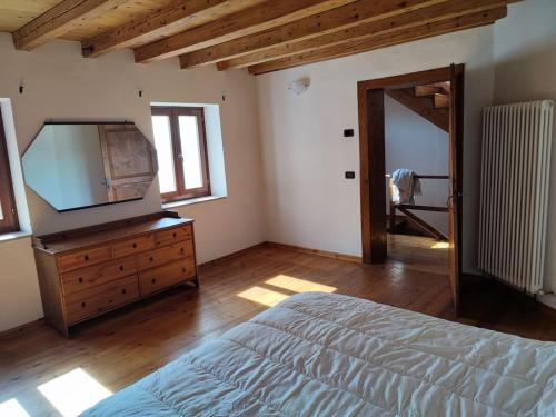 ein Schlafzimmer mit einem Bett und einer Kommode mit einem Fernseher in der Unterkunft Entire House with fireplace and private forest in Pianezze