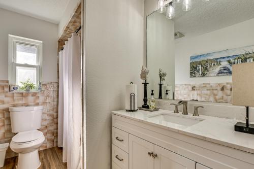 een witte badkamer met een toilet en een wastafel bij Waterfront Home on Canal with Private Dock and Kayaks in Crystal River