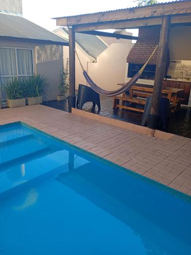 een zwembad met een hangmat naast een huis bij Brisas Iguazú II in Puerto Iguazú