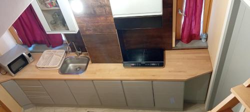 una piccola cucina con bancone e forno a microonde di Loft Mansardato a Catania