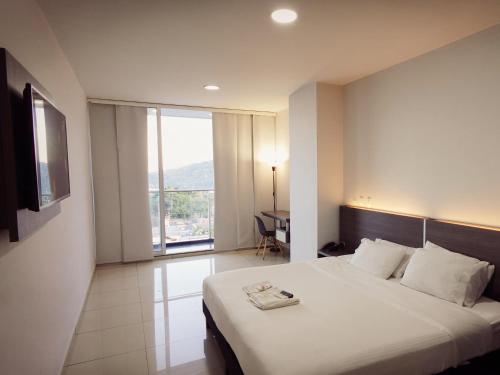 a hotel room with a bed and a large window at Hotel Doral Inn in Ibagué