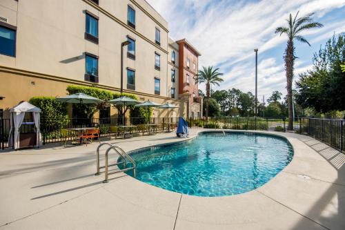 a swimming pool in front of a building at Hampton Inn & Suites Pensacola/I-10 Pine Forest Road in Pensacola