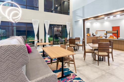 a living room with a couch and tables and chairs at Hampton Inn & Suites Pensacola/I-10 Pine Forest Road in Pensacola
