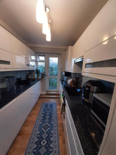 a kitchen with black counter tops and a window at Greenwich Haven, London in London