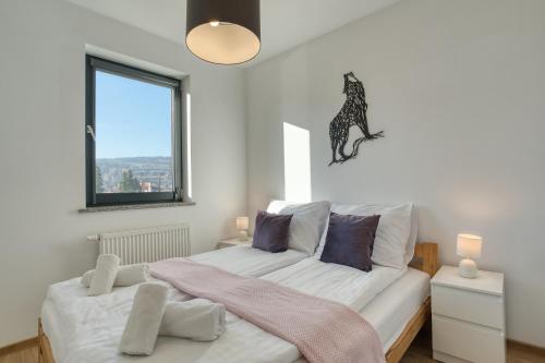 a bedroom with a bed with a dog on the wall at Wakacyjne Historie - nowoczesne i komfortowe apartamenty ze SPA u podnóża Śnieżnika in Międzylesie