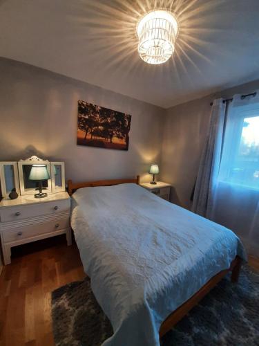 a bedroom with a large bed and a chandelier at Greenwich Haven, London in London