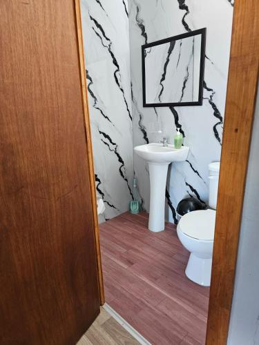 a bathroom with a toilet and a sink at Ribera del Ancoa in Llepu