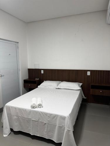 邦热苏斯-达拉帕Villa Hotel的卧室配有带鞋的大型白色床