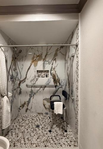 a walk in shower with a chair in a bathroom at Americas Best Value Inn & Suites-Alvin/Houston in Alvin