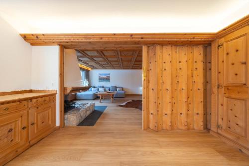 NEW Engadine Alpine Apartment - Pool & Sauna في سان موريتز: غرفة معيشة مع جدران خشبية وغرفة مع أريكة