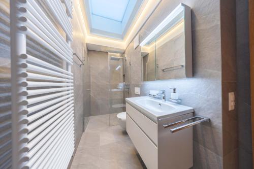 NEW Engadine Alpine Apartment - Pool & Sauna في سان موريتز: حمام مع حوض و مرحاض و منور