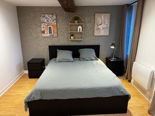 a bedroom with a large bed with two night stands at L'Escale Saint-Martin in Laon