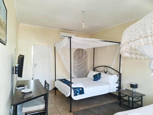 ein Schlafzimmer mit einem Himmelbett in der Unterkunft Kabula Lodge in Blantyre