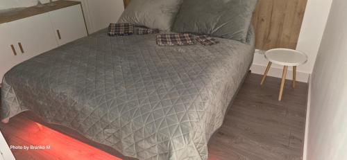 a bed with a gray comforter in a room at Apartment Feelgood in Billdal