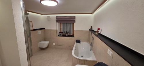 a small bathroom with a tub and a toilet at Ferienwohnung Faschinggut in Rottau