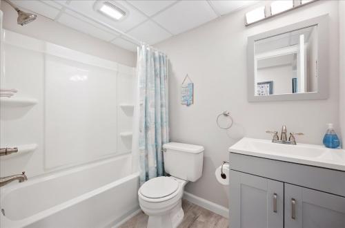 a white bathroom with a toilet and a sink at Amazing Bay view from this Assateague House Condo in Ocean City