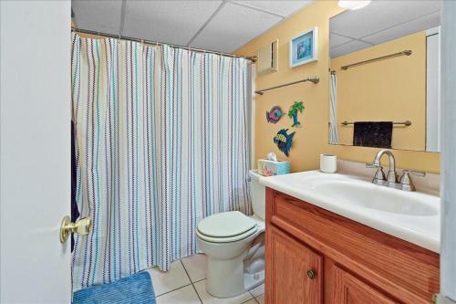 a bathroom with a toilet and a sink and a shower at One of a Kind Direct Bay Views From This 3 Bedroom Condo With Pool! in Ocean City