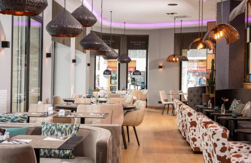 Un restaurante con mesas, sillas y luces. en NYX Hotel Bilbao by Leonardo Hotels, en Bilbao