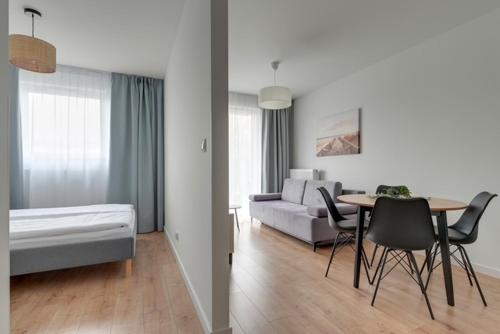 un soggiorno con un letto, un tavolo e delle sedie di Trimare Seaside Apartment a Sztutowo