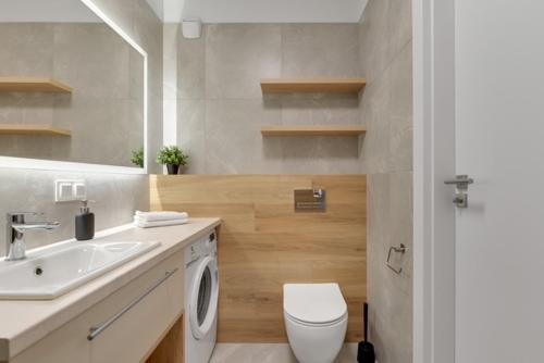 un bagno con lavandino e lavatrice di Trimare Seaside Apartment a Sztutowo