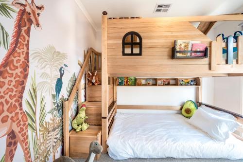 een kinderkamer met een houten stapelbed bij Bahagia Oasis in Safety Beach