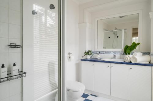 een badkamer met een douche, een toilet en een wastafel bij Bahagia Oasis in Safety Beach