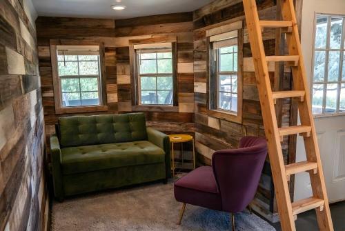 ein Wohnzimmer mit einer grünen Couch und einer Leiter in der Unterkunft The Huckleberry A Teton Tiny Home in Driggs