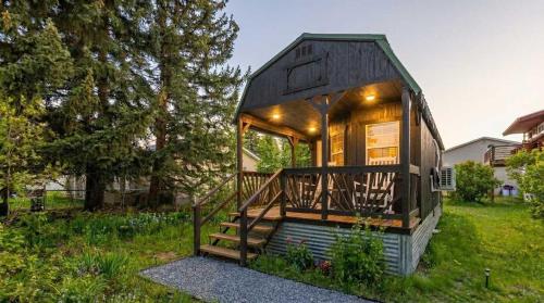 ein kleines Haus in einem Hof mit einer Veranda in der Unterkunft The Huckleberry A Teton Tiny Home in Driggs