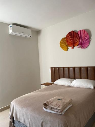 a bedroom with a bed with two umbrellas on the wall at Pousada Mariana in Holambra