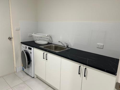 Streaky BayBeachside & Jetty View 3 - Pirate Cave No view的带水槽和洗衣机的厨房