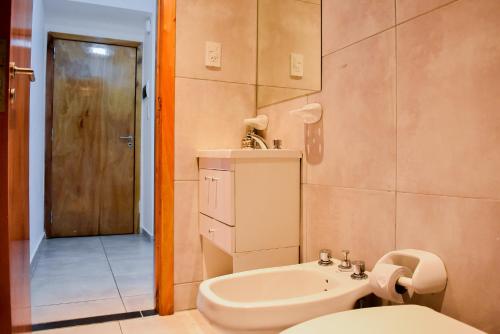 a bathroom with a toilet and a sink and a mirror at Loft Rio - Ideal turismo - Opcion a cochera! in Rosario