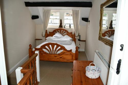 a bedroom with a wooden bed and a mirror at Neifion in Aberdyfi